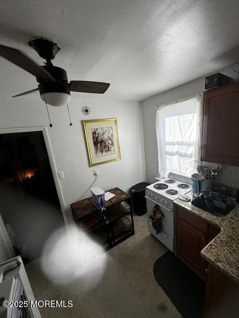 240 Beachwood Blvd, Beachwood, NJ 08722 - kitchen featuring white electric stove, ceiling fan, a textured ceiling, tasteful backsplash, and dark stone counters