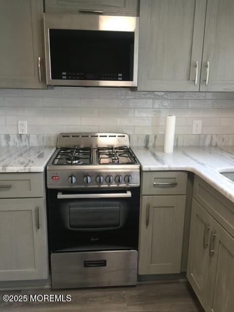 240 Beachwood Blvd, Beachwood, NJ 08722 - kitchen with stainless steel appliances, tasteful backsplash, light stone counters, and dark wood-type flooring
