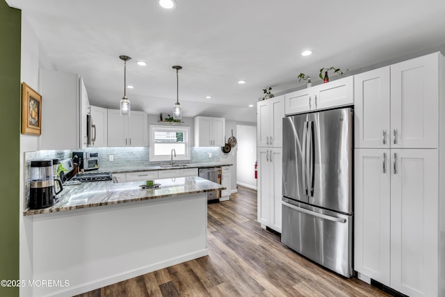208 Hilltop Blvd, Cliffwood, NJ 07735 - kitchen featuring appliances with stainless steel finishes, a peninsula, light stone countertops, white cabinets, and decorative backsplash