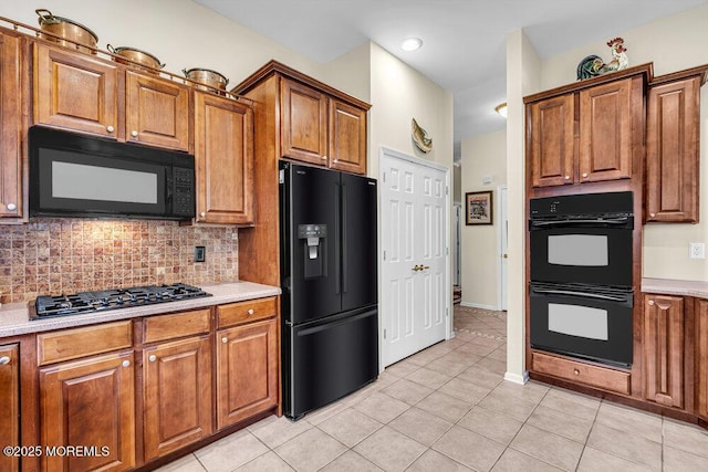 43 Bradley Beach Way, Waretown, NJ 08758 - kitchen with black appliances, brown cabinetry, light tile patterned floors, light countertops, and backsplash