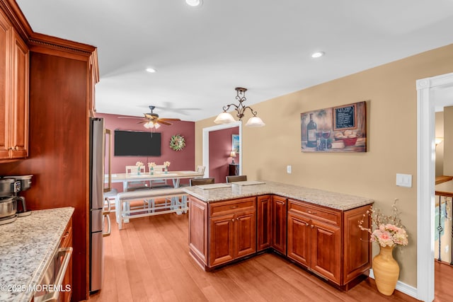 1617 Doris St, Wall, NJ 07719 - kitchen featuring ceiling fan, light wood-style flooring, brown cabinets, freestanding refrigerator, and light stone counters