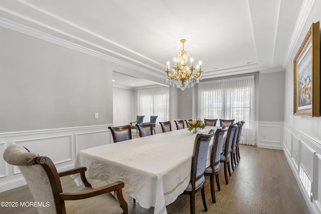 94 Bradhurst Ave, Lakewood, NJ 08701 - dining space with a decorative wall, a chandelier, a tray ceiling, light wood-style floors, and wainscoting