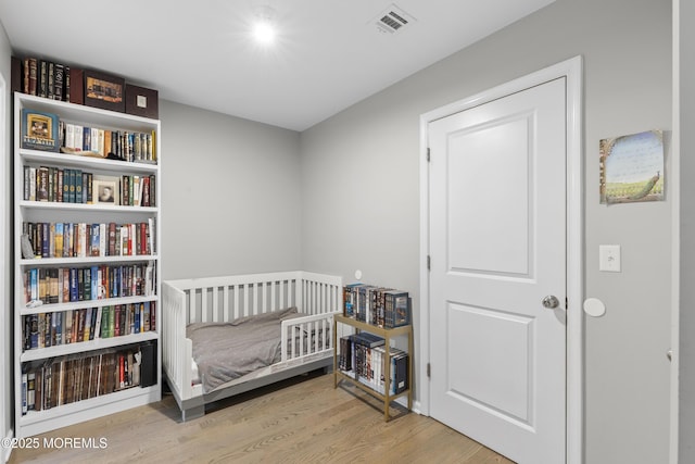 94 Bradhurst Ave, Lakewood, NJ 08701 - bedroom featuring wood finished floors and a crib