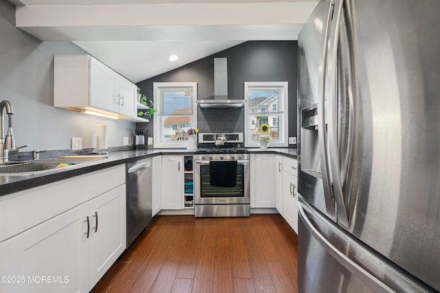 1417 Beach Blvd, Forked River, NJ 08731 - kitchen with stainless steel appliances, wall chimney exhaust hood, dark countertops, vaulted ceiling, and white cabinetry
