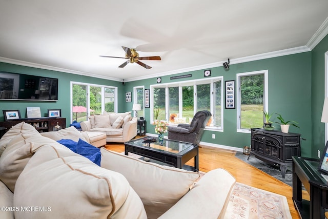 2 Darien Cir, Howell, NJ 07731 - living area with a wood stove, ornamental molding, ceiling fan, and light wood-type flooring