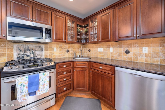 2 Darien Cir, Howell, NJ 07731 - kitchen featuring appliances with stainless steel finishes, dark stone counters, glass insert cabinets, backsplash, and brown cabinetry