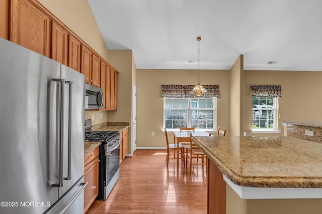12 Drayton Rd, Manchester, NJ 08759 - kitchen with appliances with stainless steel finishes, light wood-style flooring, brown cabinetry, hanging light fixtures, and light stone counters