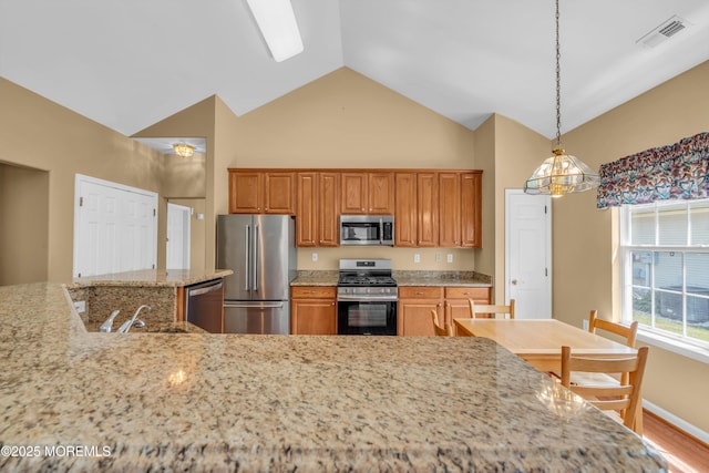 12 Drayton Rd, Manchester, NJ 08759 - kitchen with stainless steel appliances, brown cabinetry, light stone countertops, high vaulted ceiling, and hanging light fixtures