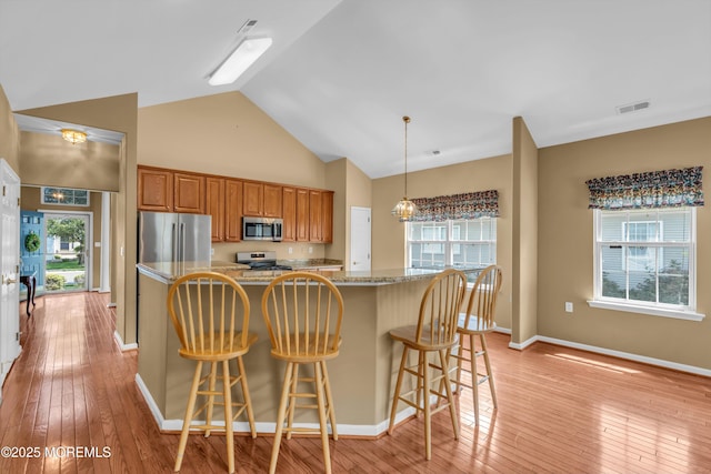 12 Drayton Rd, Manchester, NJ 08759 - kitchen featuring stainless steel appliances, brown cabinetry, a center island, light wood-type flooring, and high vaulted ceiling
