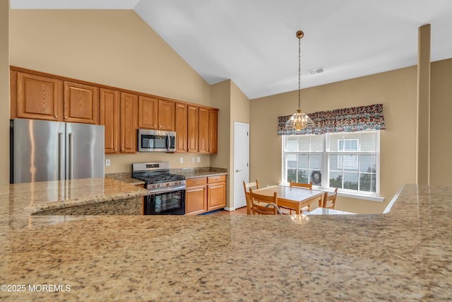 12 Drayton Rd, Manchester, NJ 08759 - kitchen featuring appliances with stainless steel finishes, brown cabinetry, light stone counters, hanging light fixtures, and high vaulted ceiling