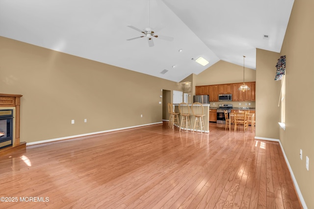 12 Drayton Rd, Manchester, NJ 08759 - unfurnished living room featuring high vaulted ceiling, ceiling fan, light wood finished floors, a glass covered fireplace, and a chandelier