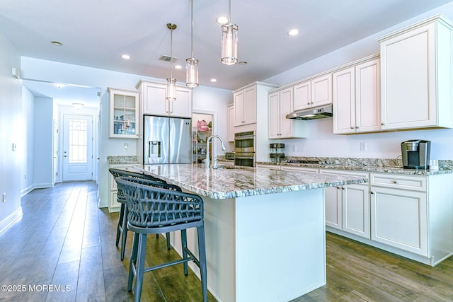 14 Festival Ct, Howell, NJ 07731 - kitchen with appliances with stainless steel finishes, wood finished floors, a breakfast bar area, glass insert cabinets, and a kitchen island with sink