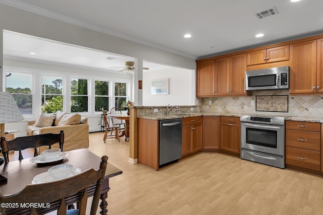 52 Kettle Creek Dr, Brick, NJ 08723 - kitchen featuring stainless steel appliances, brown cabinetry, light wood-type flooring, ornamental molding, and recessed lighting