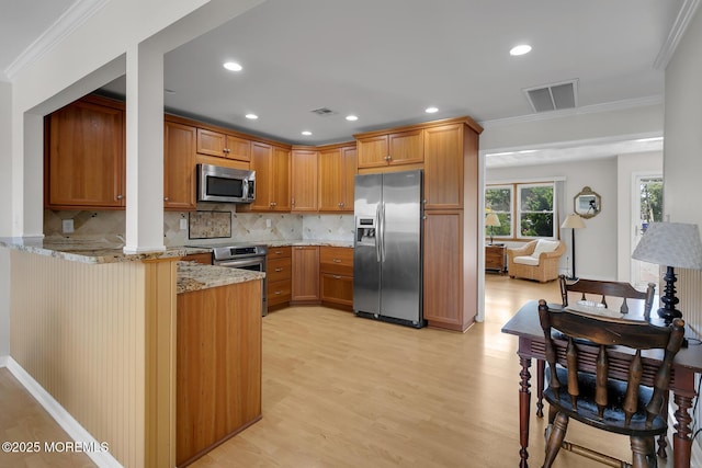 52 Kettle Creek Dr, Brick, NJ 08723 - kitchen featuring stainless steel appliances, light stone counters, a peninsula, light wood finished floors, and ornamental molding