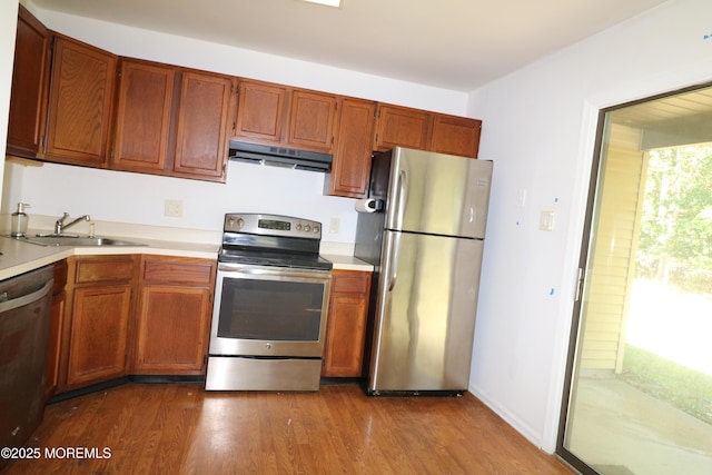 120 Lexington Dr, Little Egg Harbor, NJ 08087 - kitchen featuring stainless steel appliances, under cabinet range hood, light countertops, dark wood-style floors, and brown cabinetry