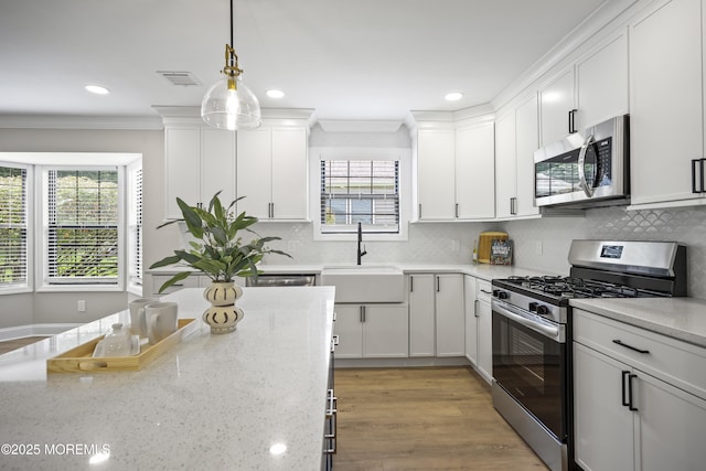 12 Weston Ct, Marlboro, NJ 07746 - kitchen featuring stainless steel appliances, healthy amount of natural light, white cabinetry, ornamental molding, and recessed lighting