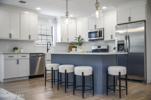 12 Weston Ct, Marlboro, NJ 07746 - kitchen featuring stainless steel appliances, white cabinets, a kitchen bar, a kitchen island, and recessed lighting