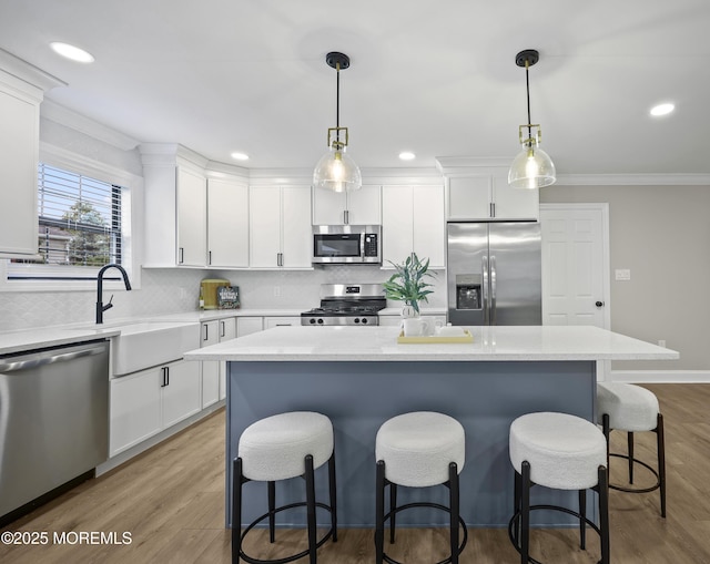 12 Weston Ct, Marlboro, NJ 07746 - kitchen with appliances with stainless steel finishes, ornamental molding, white cabinetry, a breakfast bar area, and decorative backsplash