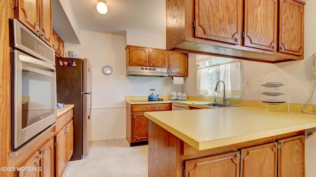 20 Kenwood Ln, Old Bridge, NJ 08857 - kitchen featuring under cabinet range hood, appliances with stainless steel finishes, a peninsula, and light countertops