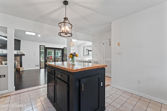 102 Oak Glen Rd, Toms River, NJ 08753 - kitchen featuring butcher block counters, dark cabinets, a chandelier, light tile patterned floors, and pendant lighting