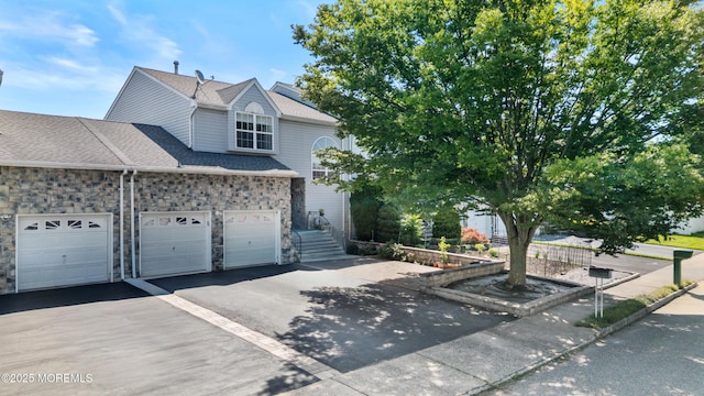 7 Warbler Rd, Marlboro, NJ 07746 - view of front of house with stone siding, driveway, roof with shingles, and an attached garage