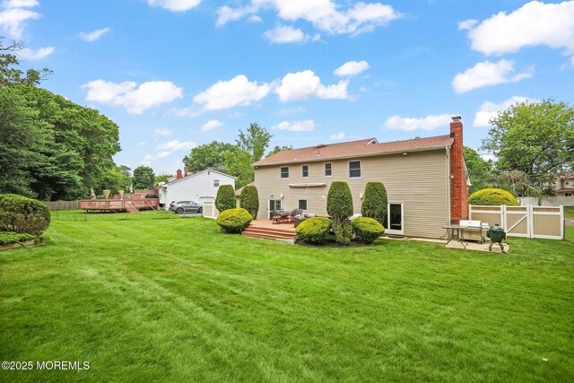 3 Sudbury Rd, Morganville, NJ 07751 - rear view of property featuring a wooden deck, a chimney, and a gate