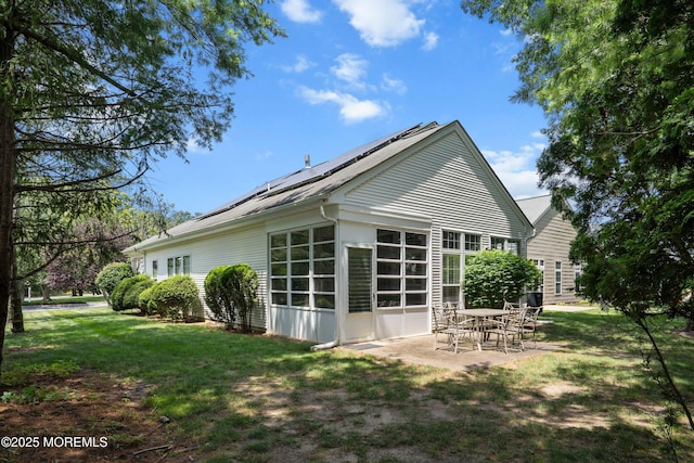 1 Silverspring Dr, Lakewood, NJ 08701 - rear view of house featuring roof mounted solar panels, a patio area, and a lawn