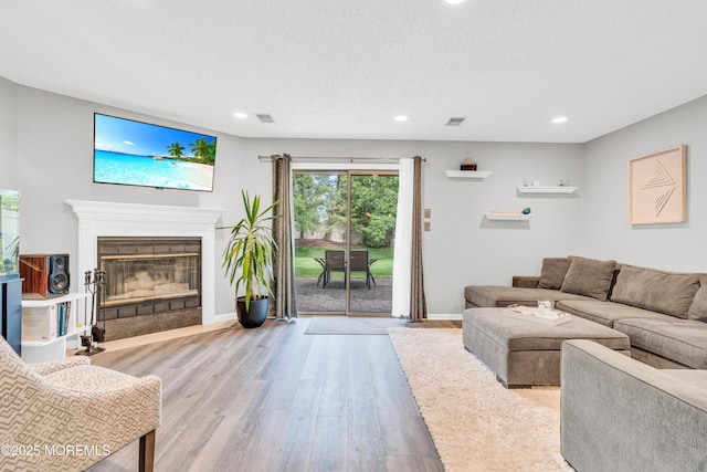 18 Remington Dr Unit 5, Freehold, NJ 07728 - living area with wood finished floors, recessed lighting, a glass covered fireplace, and a textured ceiling