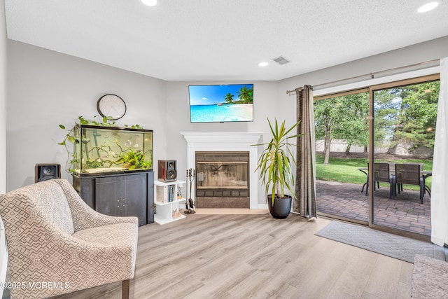 18 Remington Dr Unit 5, Freehold, NJ 07728 - living area with wood finished floors, recessed lighting, a glass covered fireplace, and a textured ceiling