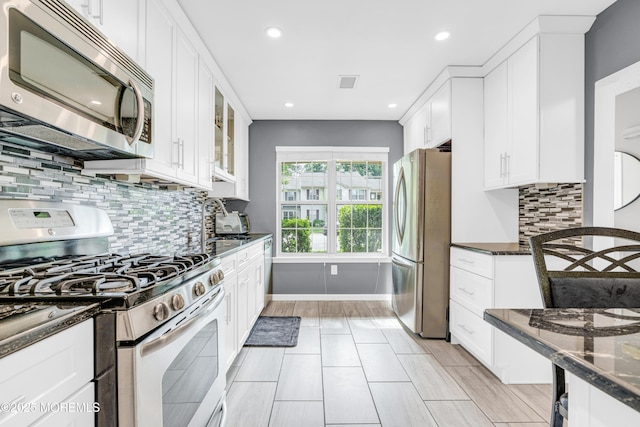 18 Remington Dr Unit 5, Freehold, NJ 07728 - kitchen with stainless steel appliances, white cabinetry, dark stone counters, recessed lighting, and decorative backsplash