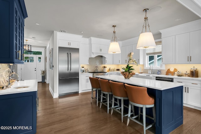 29 Allen St, Rumson, NJ 07760 - kitchen featuring appliances with stainless steel finishes, blue cabinets, a center island, a breakfast bar area, and backsplash