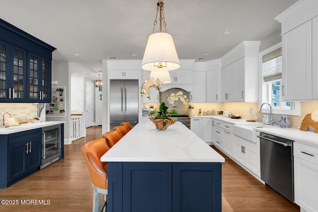 29 Allen St, Rumson, NJ 07760 - kitchen with appliances with stainless steel finishes, beverage cooler, blue cabinets, a breakfast bar, and backsplash