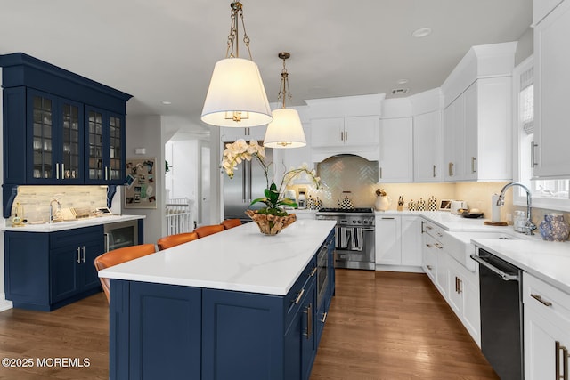 29 Allen St, Rumson, NJ 07760 - kitchen featuring stainless steel appliances, blue cabinetry, a kitchen island, backsplash, and recessed lighting