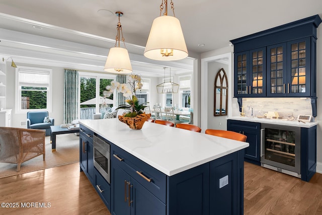 29 Allen St, Rumson, NJ 07760 - kitchen with beverage cooler, blue cabinets, light wood-style flooring, light countertops, and stainless steel microwave