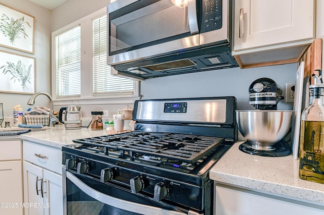 241 Hancock Ave, Seaside Heights, NJ 08751 - kitchen with stainless steel appliances, white cabinets, and light stone counters