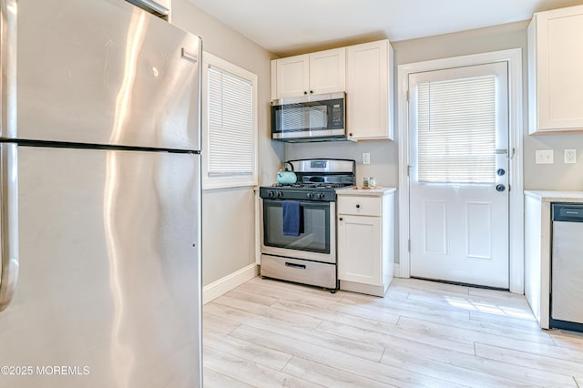 241 Hancock Ave, Seaside Heights, NJ 08751 - kitchen featuring appliances with stainless steel finishes, light wood-type flooring, white cabinetry, light countertops, and healthy amount of natural light