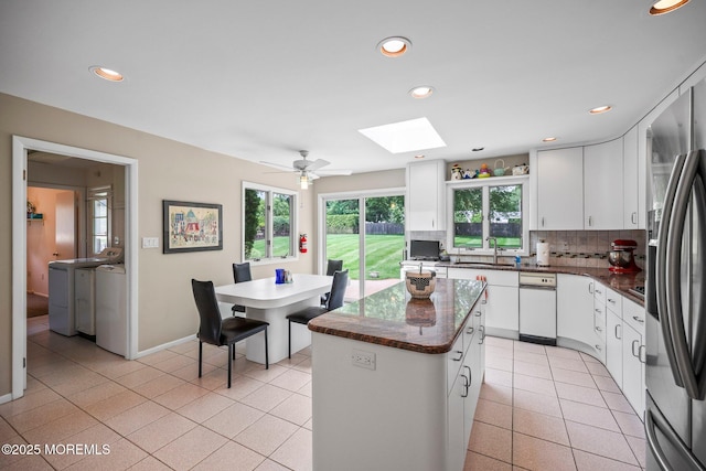 6 Pamela St, Marlboro, NJ 07746 - kitchen featuring separate washer and dryer, decorative backsplash, a skylight, recessed lighting, and light tile patterned floors