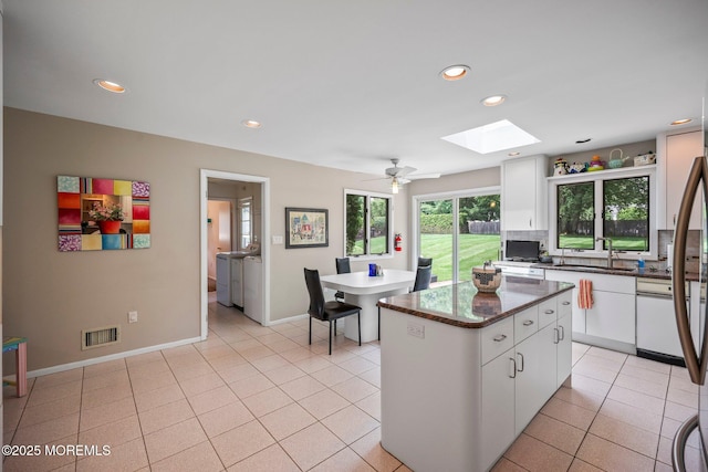 6 Pamela St, Marlboro, NJ 07746 - kitchen with recessed lighting, a kitchen island, white cabinetry, a skylight, and dark stone countertops