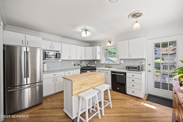 505 Moore Rd, Neptune Township, NJ 07753 - kitchen with appliances with stainless steel finishes, ornamental molding, white cabinetry, backsplash, and a breakfast bar