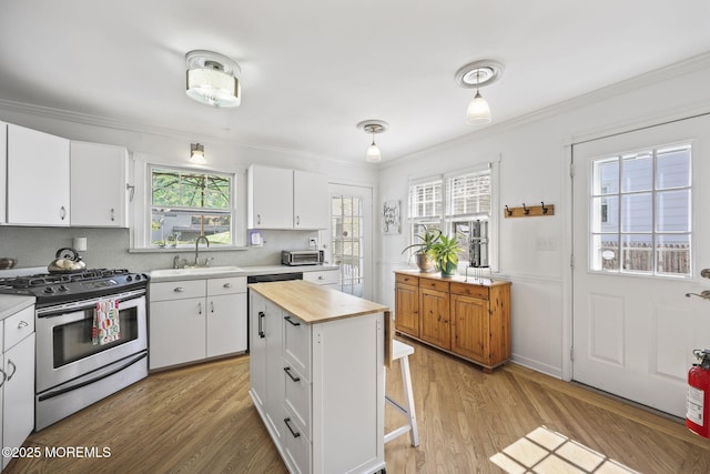 505 Moore Rd, Neptune Township, NJ 07753 - kitchen with stainless steel gas range oven, butcher block counters, crown molding, white cabinetry, and a kitchen breakfast bar