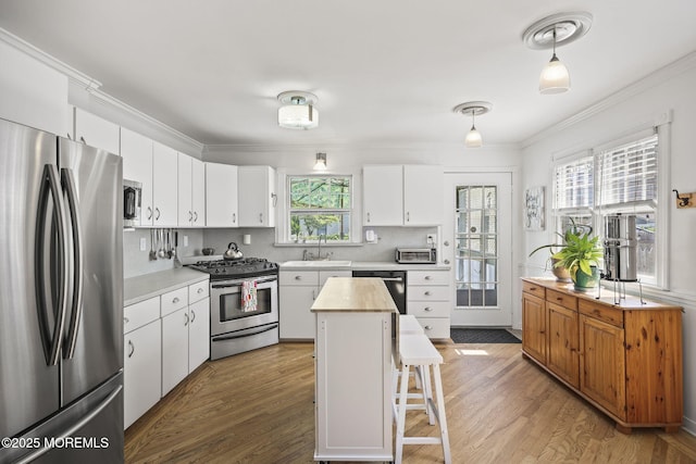 505 Moore Rd, Neptune Township, NJ 07753 - kitchen featuring stainless steel appliances, light wood-style floors, ornamental molding, white cabinets, and backsplash