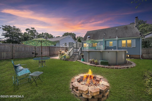 505 Moore Rd, Neptune Township, NJ 07753 - yard at dusk with a fire pit, a wooden deck, and a fenced backyard