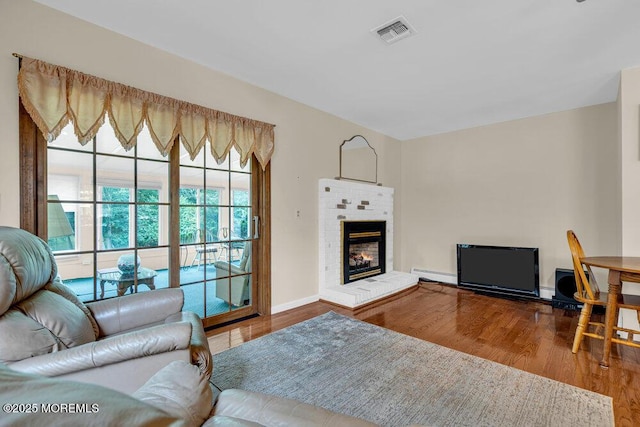 119 Barbados Dr S, Toms River, NJ 08757 - living area featuring a baseboard radiator, wood finished floors, and a brick fireplace