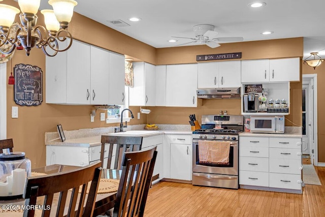 7 Crest Rd, Jackson, NJ 08527 - kitchen featuring stainless steel range with gas cooktop, under cabinet range hood, white microwave, a ceiling fan, and light countertops