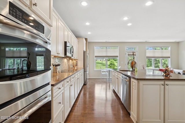 6 Day Star Rd, Manalapan, NJ 07726 - kitchen featuring stainless steel appliances, recessed lighting, dark wood-type flooring, an island with sink, and decorative backsplash