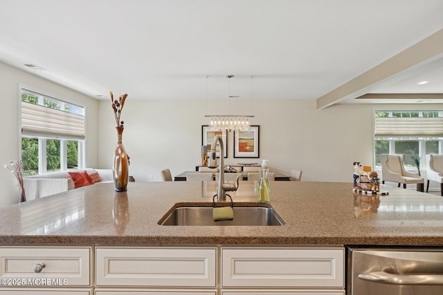 6 Day Star Rd, Manalapan, NJ 07726 - kitchen featuring stainless steel dishwasher, light stone countertops, healthy amount of natural light, and cream cabinets