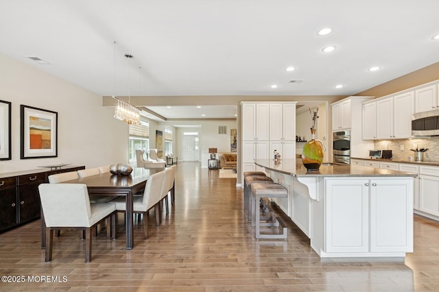 6 Day Star Rd, Manalapan, NJ 07726 - kitchen with appliances with stainless steel finishes, light wood-style flooring, recessed lighting, white cabinets, and decorative backsplash