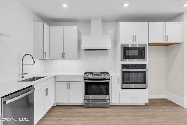 218 3rd Ave Unit 204, Asbury Park, NJ 07712 - kitchen with appliances with stainless steel finishes, wall chimney range hood, light countertops, white cabinets, and recessed lighting