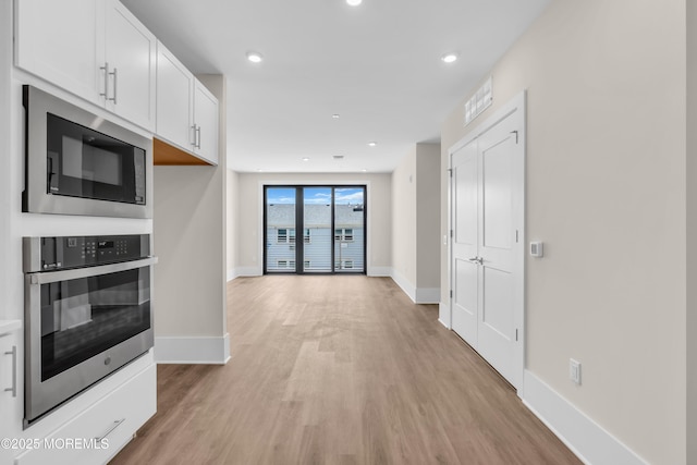 218 3rd Ave Unit 204, Asbury Park, NJ 07712 - kitchen with black microwave, oven, light wood-type flooring, white cabinets, and recessed lighting