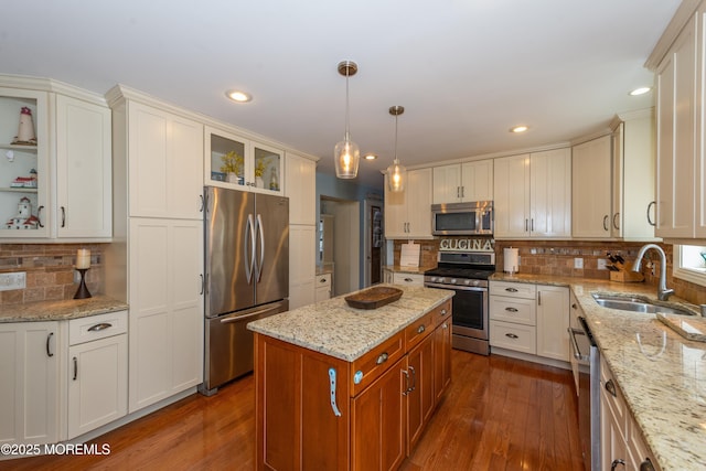 45 Fielder Ave, Seaside Heights, NJ 08751 - kitchen with appliances with stainless steel finishes, dark wood-style floors, tasteful backsplash, light stone counters, and a center island
